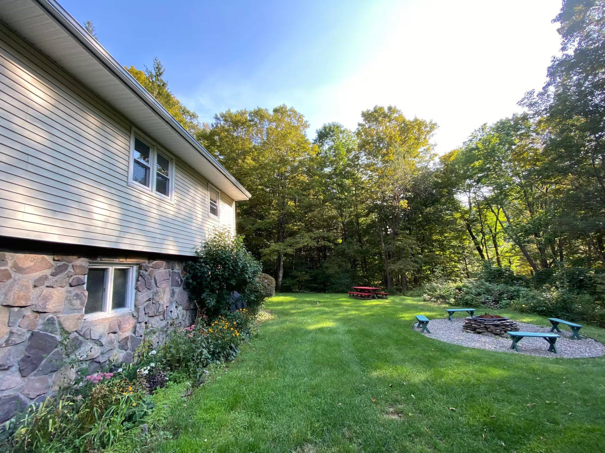 Mid-century modern ski house exterior with stone foundation, surrounded by Catskills forest in Shandaken, NY